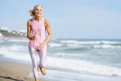 Senior woman running by the sea